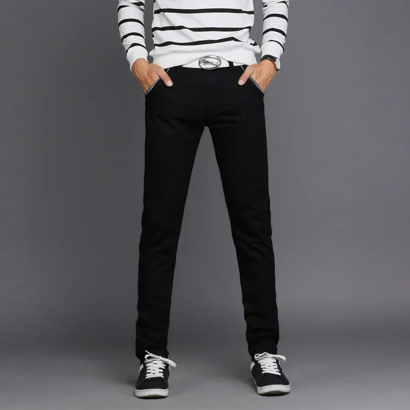 Man wearing slim fit black pants with a silver buckle belt and striped long sleeve shirt