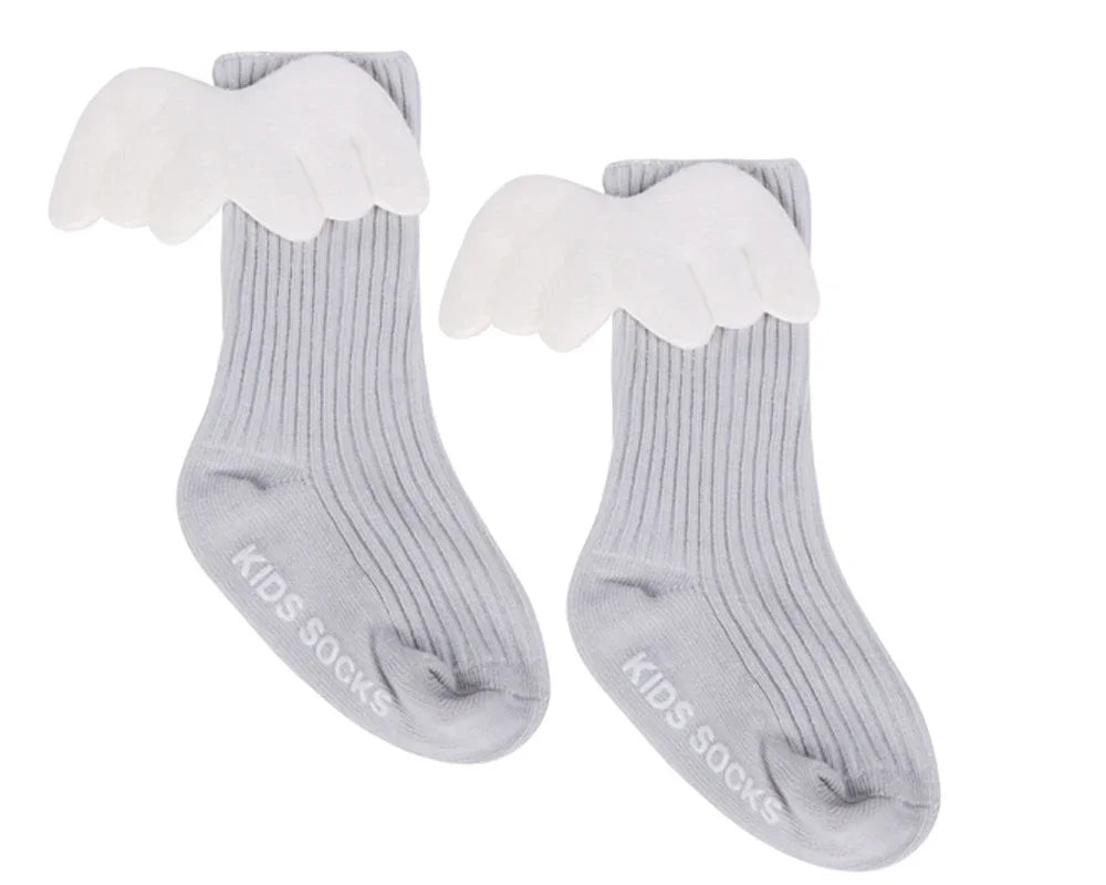 Pair of gray ribbed kids socks with white angel wings attached on white background
