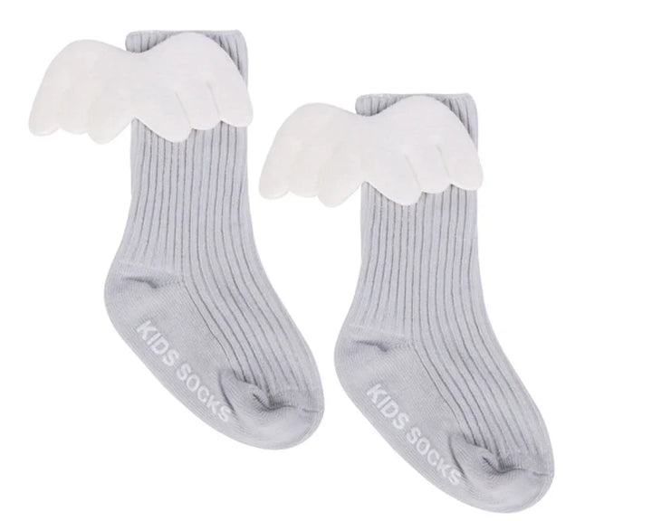 Pair of gray ribbed kids socks with white angel wings attached on white background