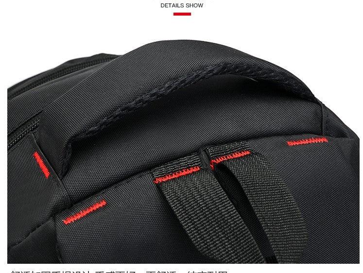 Close-up of black backpack handle and straps with red reinforced stitching detail