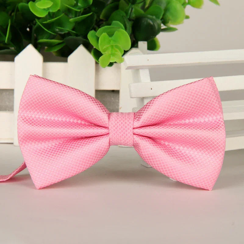 Elegant pink textured satin bow tie with geometric pattern displayed on white surface