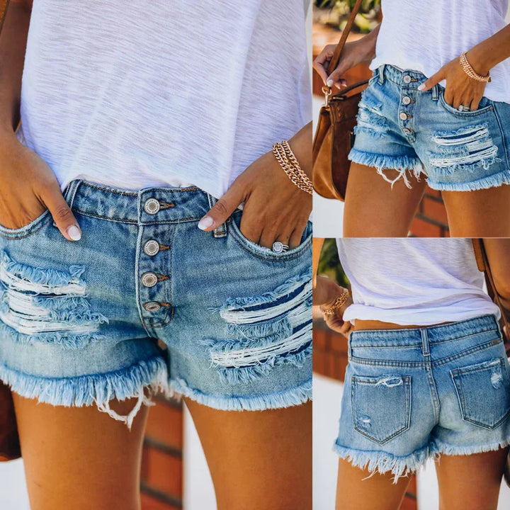 Woman wearing distressed denim shorts with button fly, white t-shirt, and gold bracelet accessories
