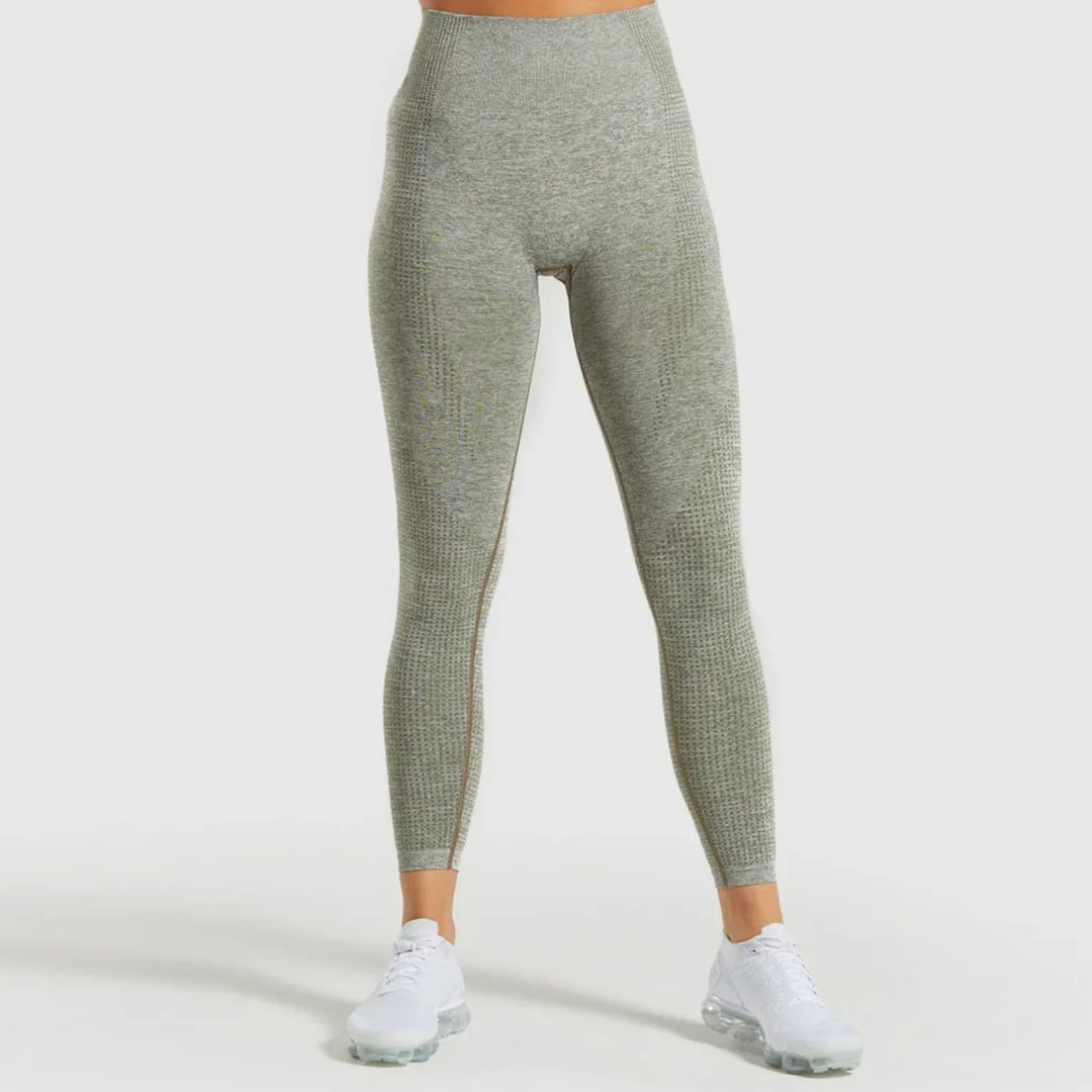 Front view of woman wearing grey high-waisted seamless textured leggings and white sneakers