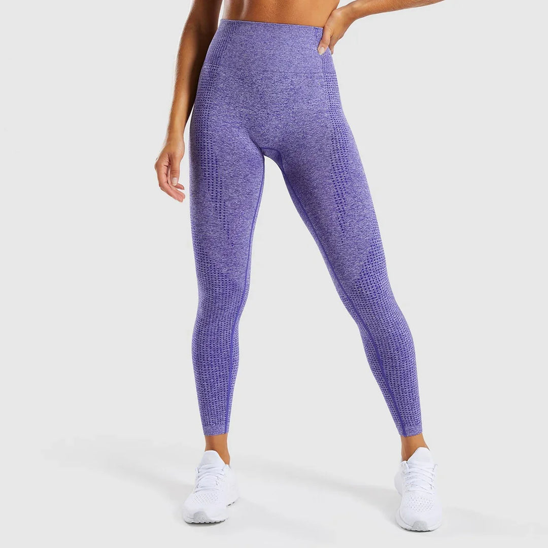 Front view of woman wearing seamless purple textured high-waisted leggings and white sneakers on gray background