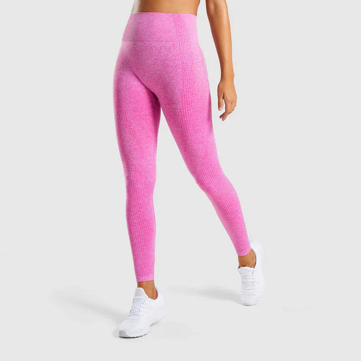 woman wearing seamless high-waisted pink workout leggings and white sneakers on white background