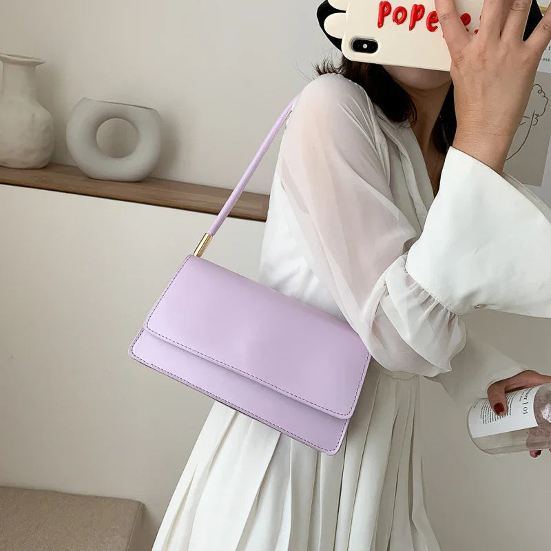 Woman in white dress holding lilac shoulder bag taking mirror selfie with phone case saying 'Popee'