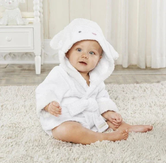 Baby sitting on carpet wearing white hooded bathrobe with animal ears in bright nursery