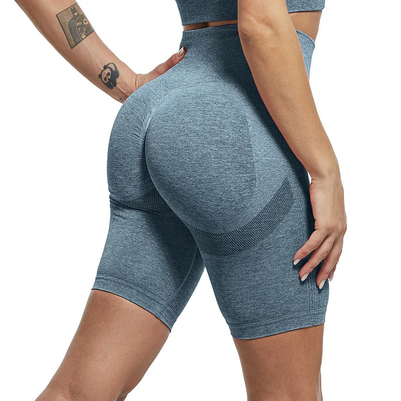 Close-up of woman wearing seamless grey high-waisted shaping shorts with textured panels and tattoos