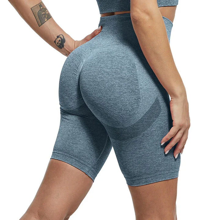 Close-up of woman wearing seamless grey high-waisted shaping shorts with textured panels and tattoos