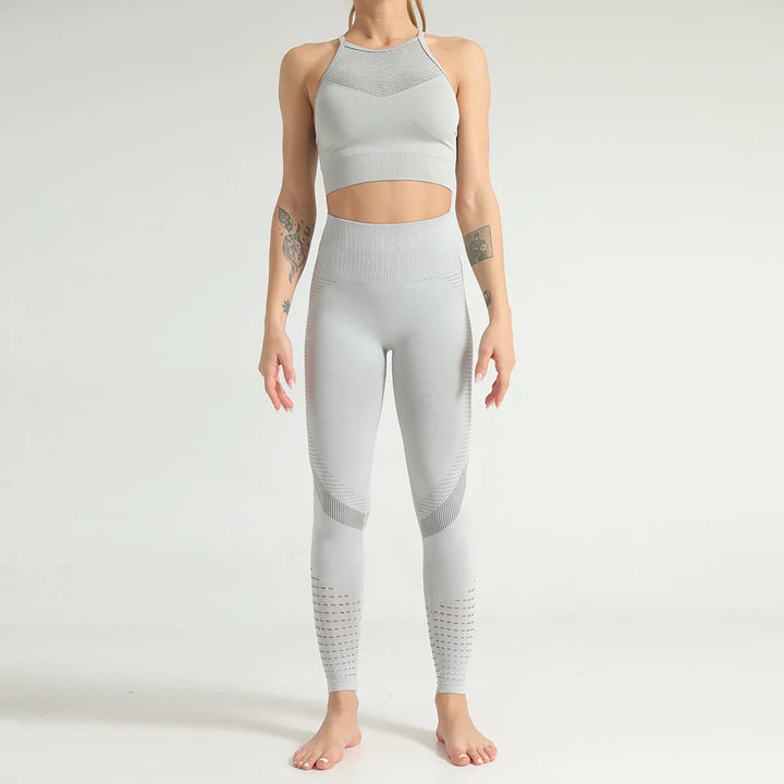 Woman wearing seamless light gray high-waisted leggings and matching crop top with tattoos visible