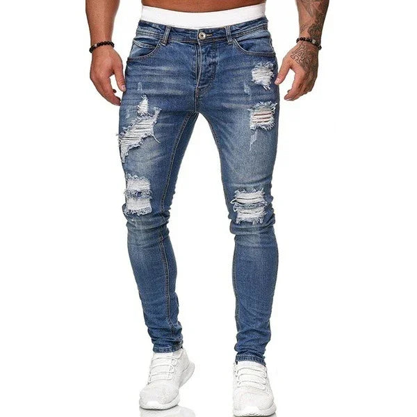 Men's slim-fit blue distressed ripped jeans with white sneakers on white background