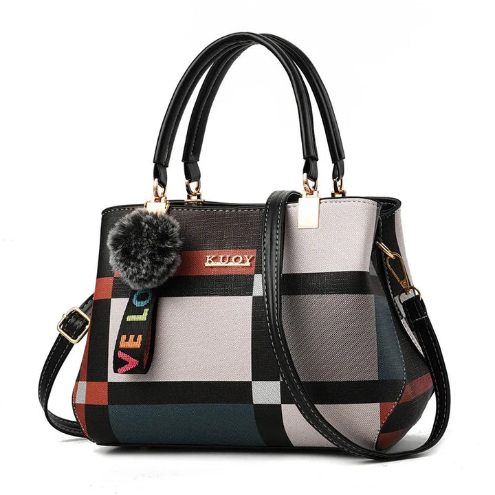 Fashionable multicolor checkered handbag with black handles, gold accents, and a furry pom-pom charm