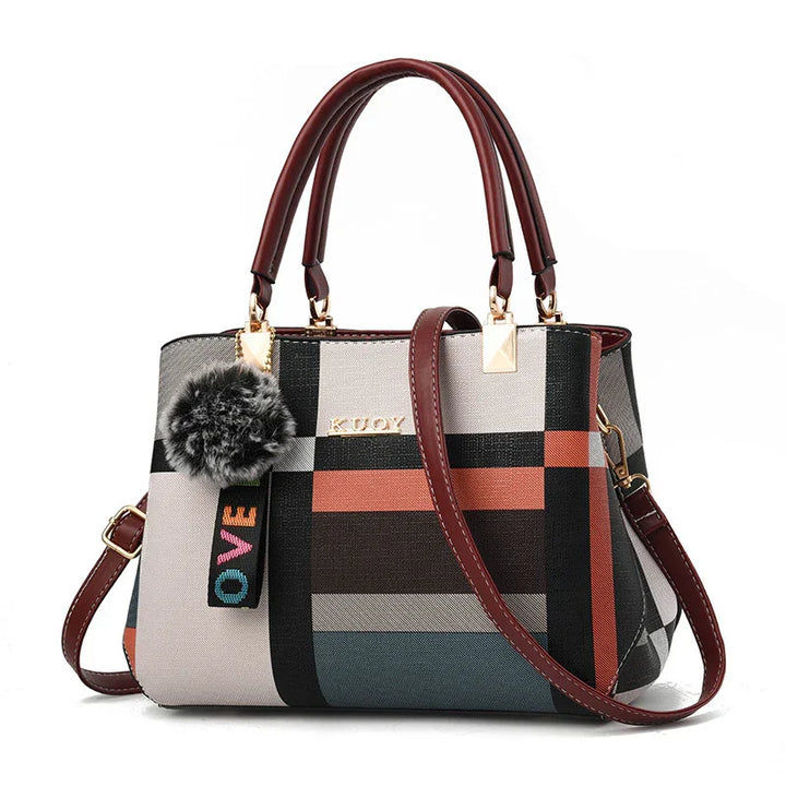 Stylish multicolor plaid handbag with brown handles, gold hardware, and fuzzy pom-pom keychain