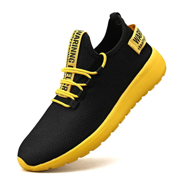 Black and yellow athletic sneaker with mesh upper, yellow sole, and warning text on tongue and heel tab