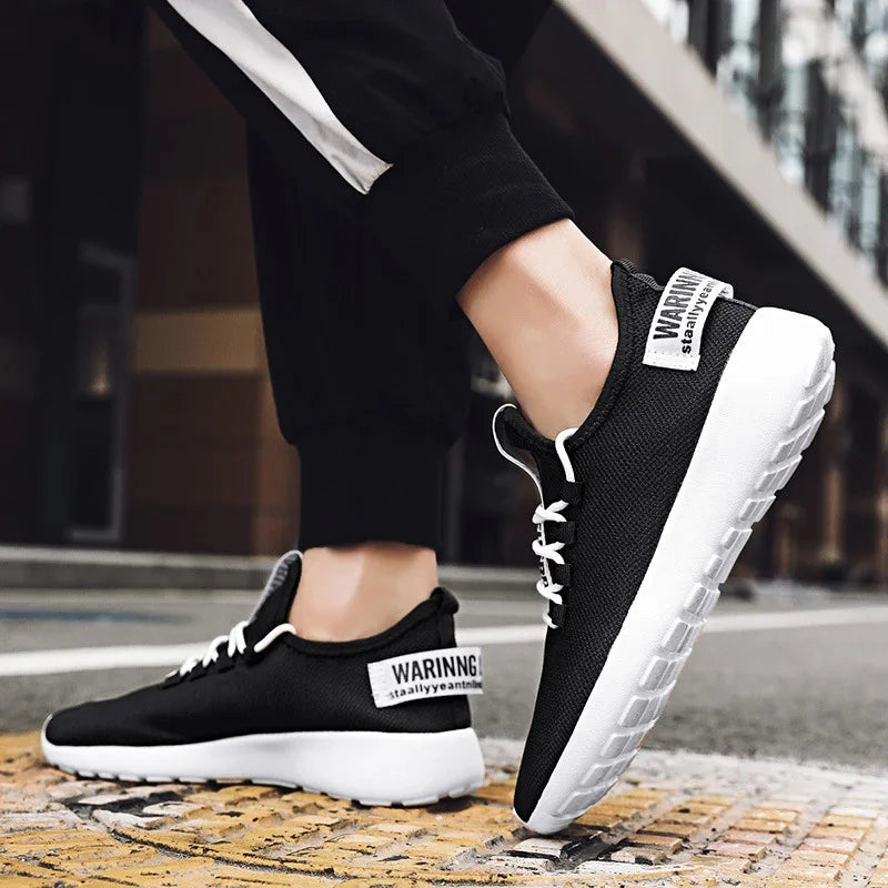 Close-up of black and white sporty sneakers with white laces on urban pavement