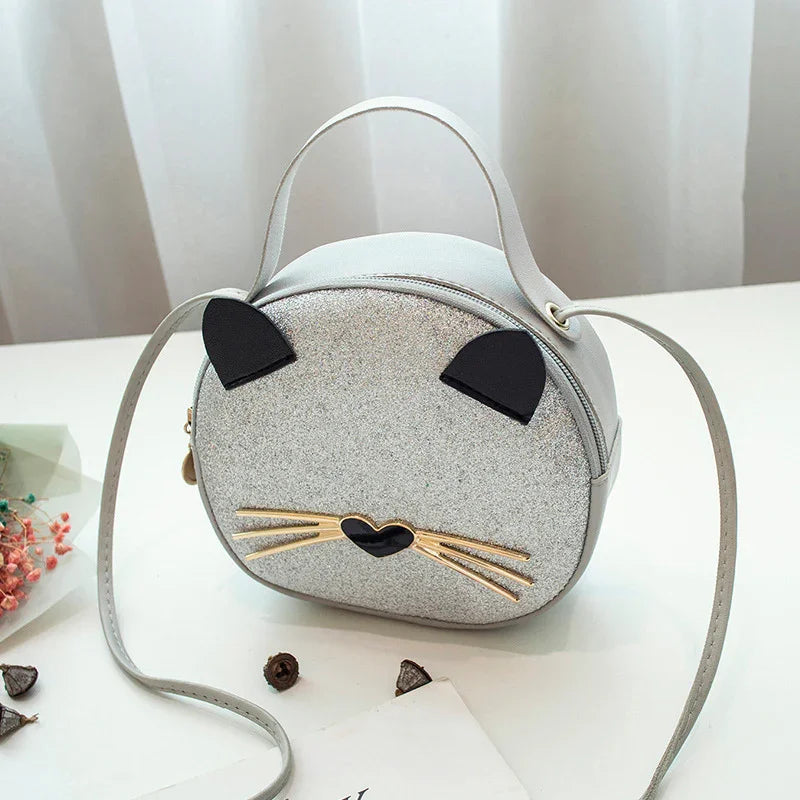 Silver glitter round crossbody bag with cat ears and whiskers on white surface