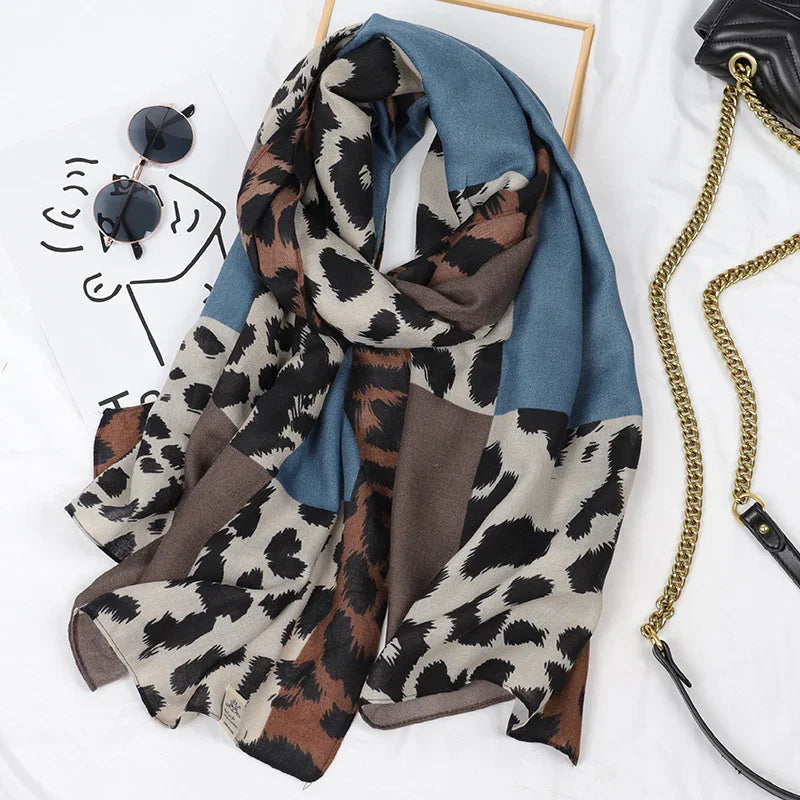 Fashion leopard print scarf with blue and brown blocks, paired with round sunglasses and black purse with gold chain