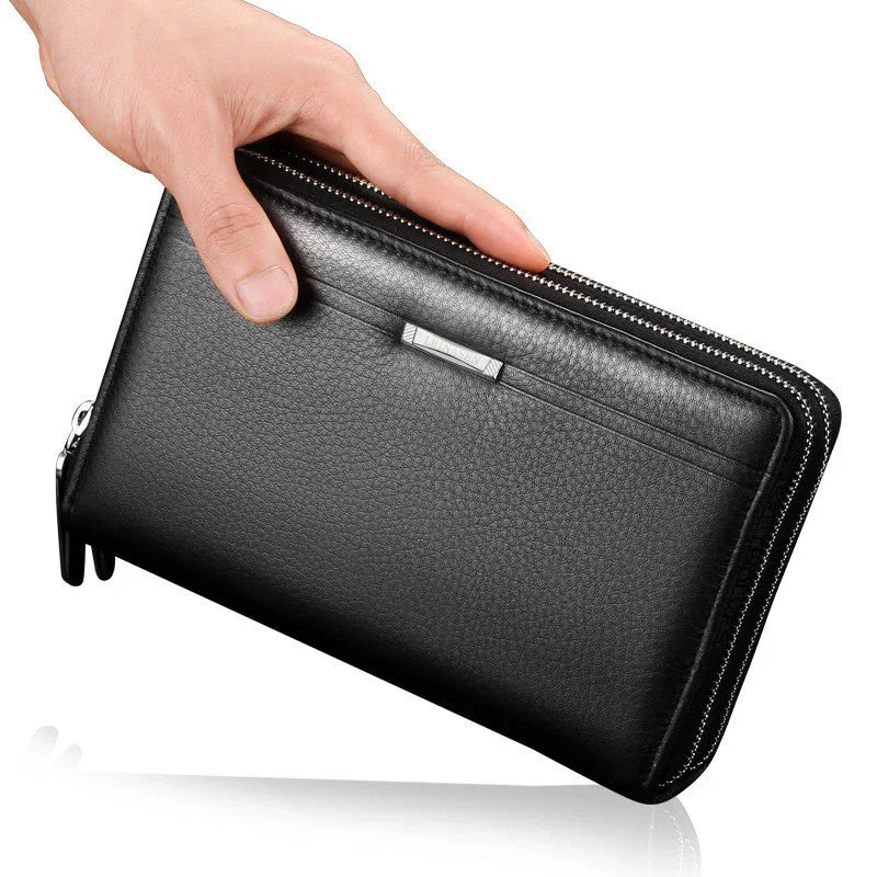 Hand holding black leather zip-around wallet with textured finish and silver zipper