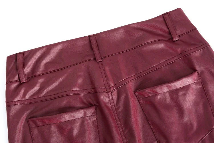 Close-up of maroon faux leather pants with back pockets and belt loops