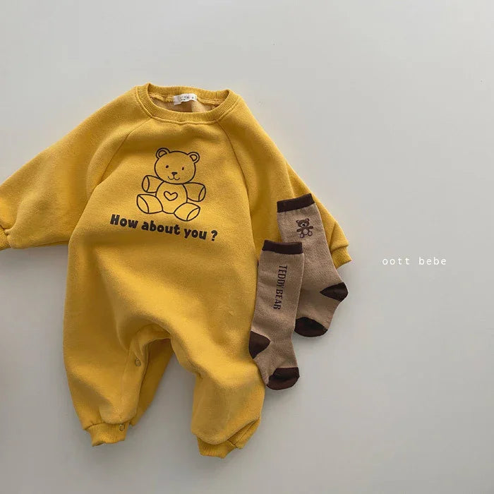 Yellow baby romper with teddy bear graphic and text How about you? paired with brown teddy bear socks