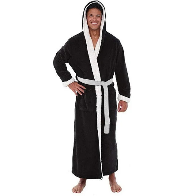 Man wearing a black hooded bathrobe with white fleece lining and a gray belt, standing barefoot