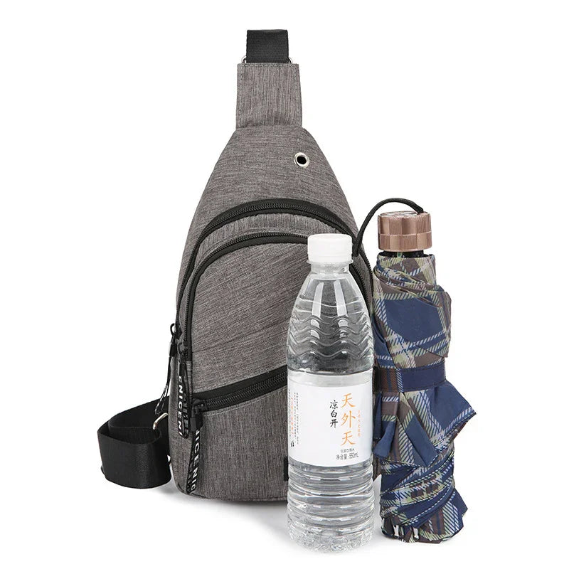 gray sling backpack with black zippers, water bottle with Asian label, and folded plaid umbrella
