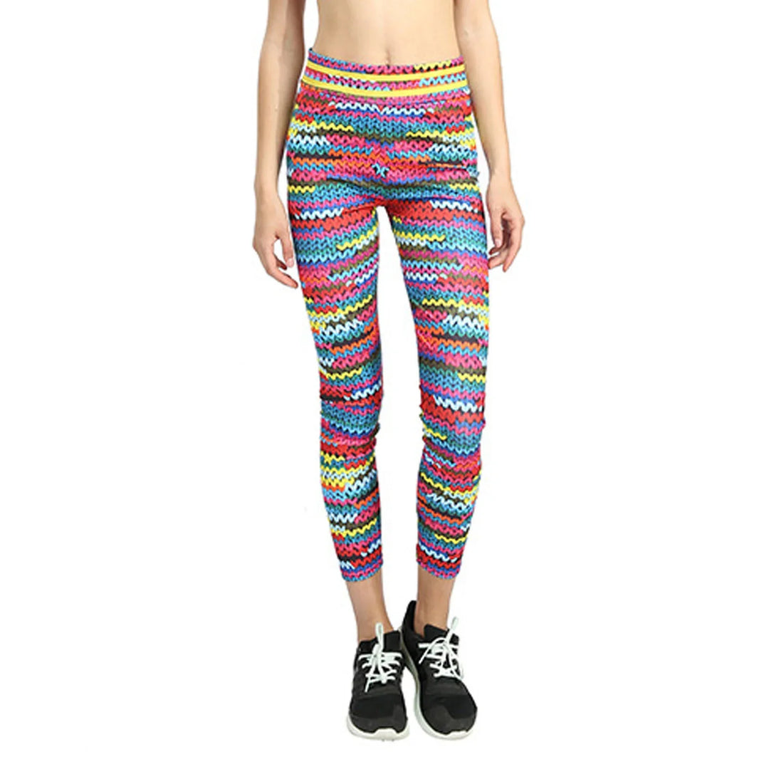 Woman wearing colorful zigzag pattern leggings and black sneakers on white background