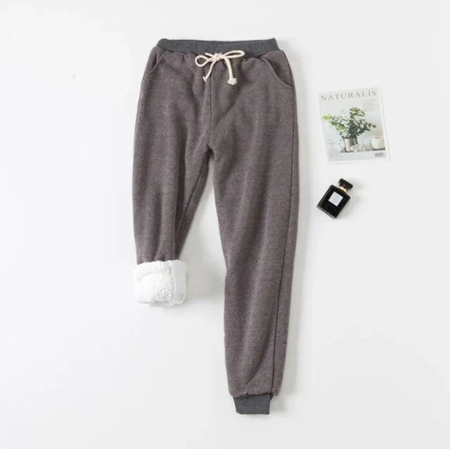 Gray fleece-lined sweatpants with drawstring waist, rolled cuff showing white plush lining, flat lay on white background