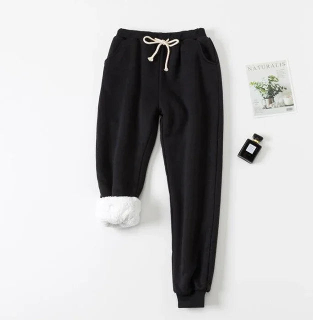Black fleece lined jogger pants with white drawstring, rolled up to show plush lining