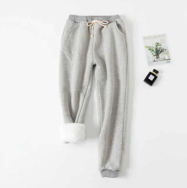 Gray fleece-lined sweatpants with drawstring waist and pockets on white background