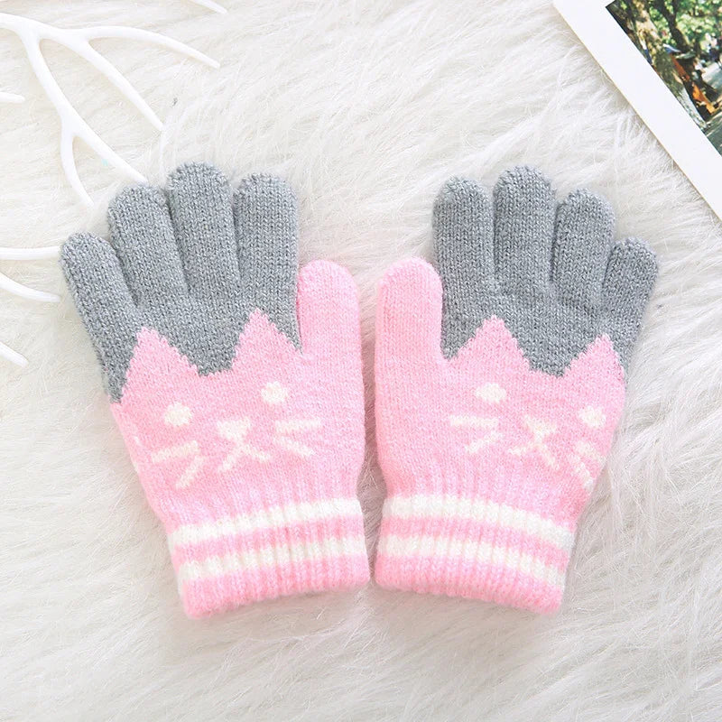 Pink and gray knitted cat design gloves on soft white fur background