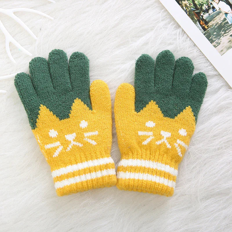 Pair of cozy knit gloves with green fingers and yellow cuffs featuring white cat face design