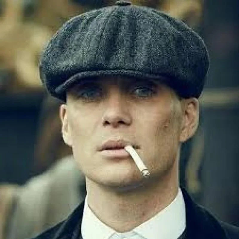 Close-up of man wearing gray newsboy cap smoking cigarette, vintage 1920s style