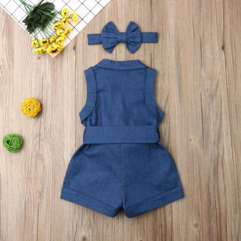 Blue denim sleeveless baby romper with matching bow headband on wooden surface