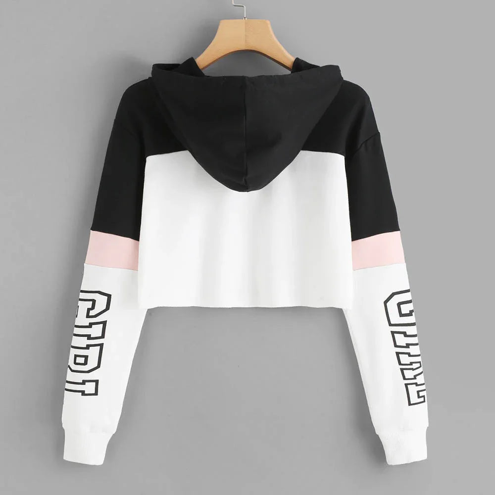 Black, white, and pink cropped hoodie with CREW text on white sleeves hanging on wooden hanger
