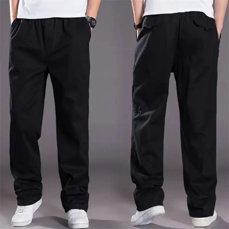 Front and back view of black casual pants with elastic waist worn with white sneakers