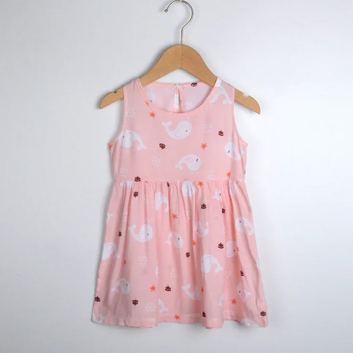 Pink sleeveless toddler dress with white whale and sea-themed prints hanging on wooden hanger