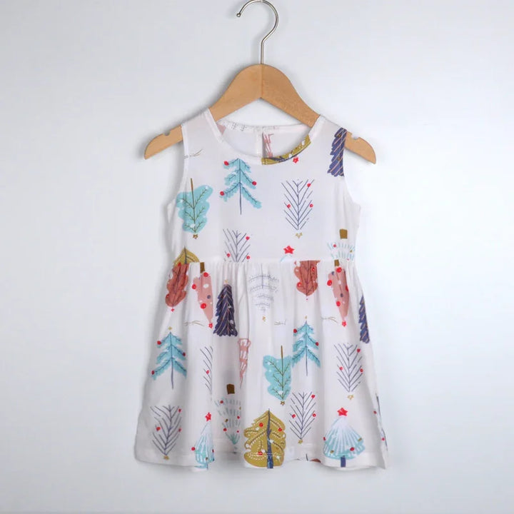 White sleeveless toddler dress with colorful Christmas tree print hanging on wooden hanger