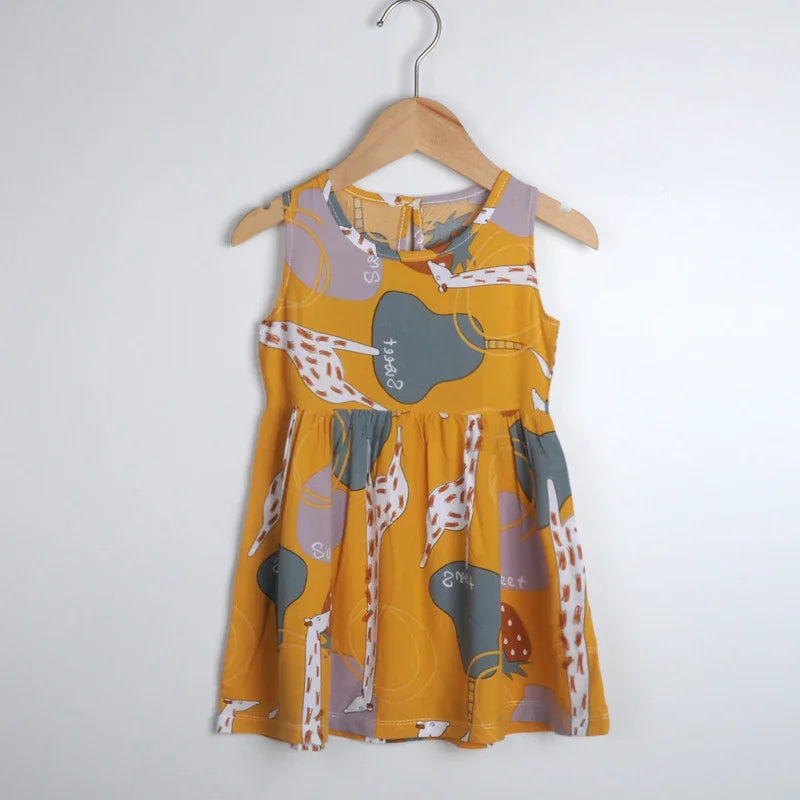 Yellow sleeveless toddler dress with giraffe and mushroom print on wooden hanger