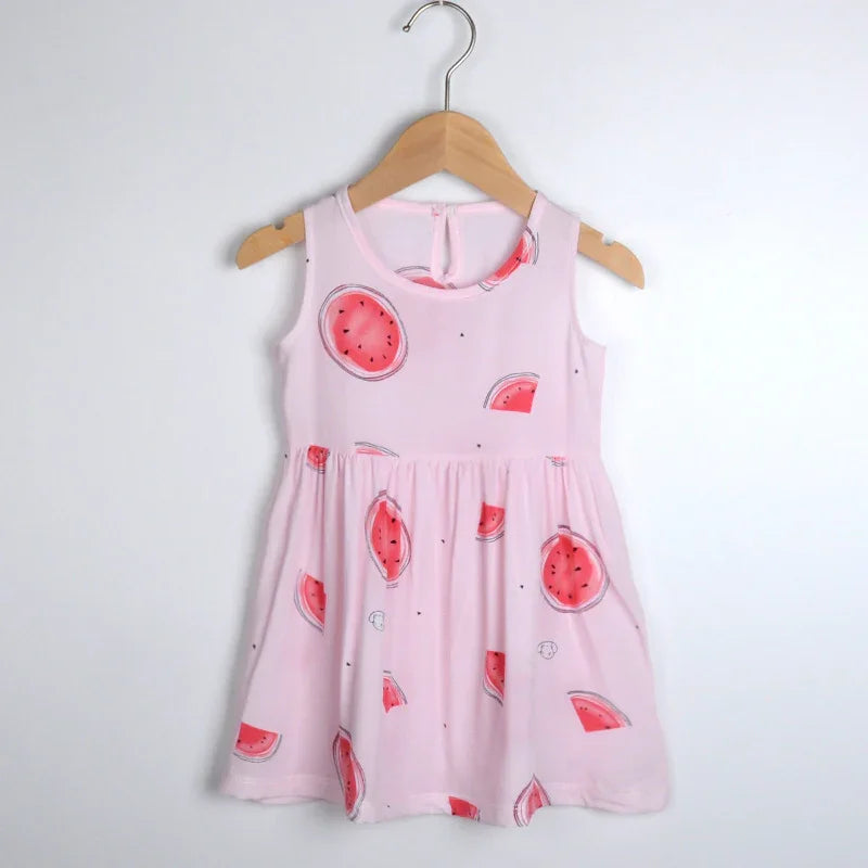 Sleeveless pink toddler dress with watermelon print hanging on wooden hanger