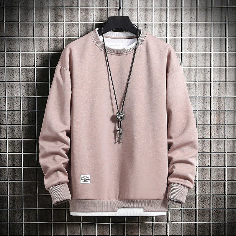 Light pink crew neck sweatshirt with ribbed cuffs and hem, displayed on black hanger against wire grid background