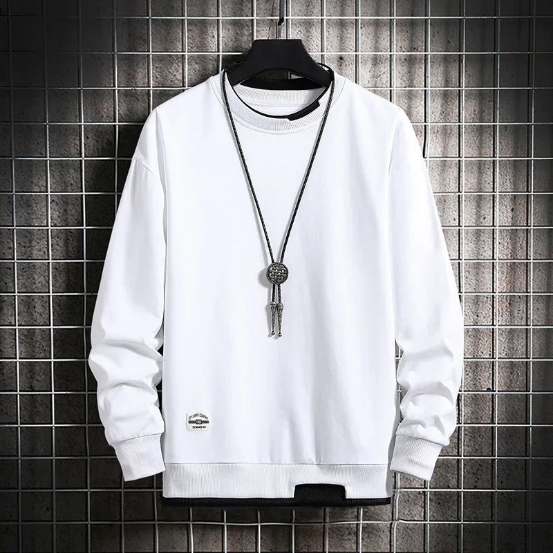 White long sleeve crewneck sweatshirt with black layered hem detail and silver pendant necklace