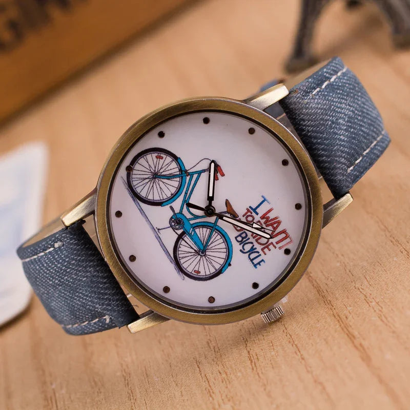Wristwatch with blue denim strap and dial featuring a blue bicycle and text 'I want to ride bicycle'