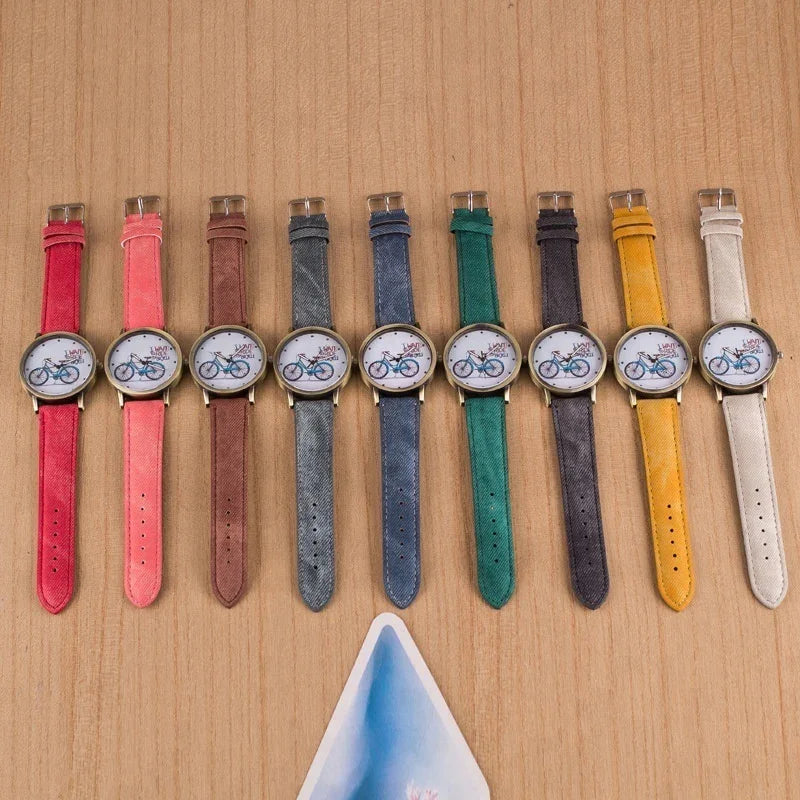 Colorful wristwatches with bicycle design faces arranged on wooden surface in various pastel and vibrant straps