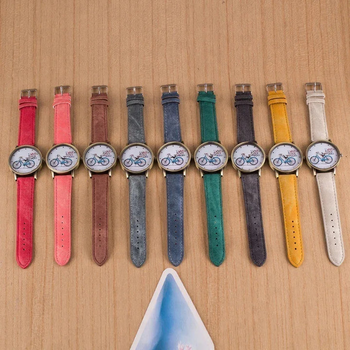 Colorful wristwatches with bicycle design faces arranged on wooden surface in various pastel and vibrant straps