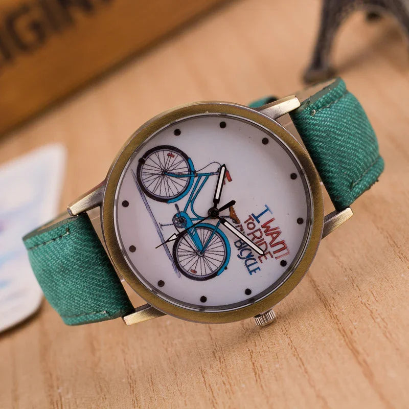 Vintage wristwatch with teal strap and bicycle illustration on dial with I want to ride bicycle text