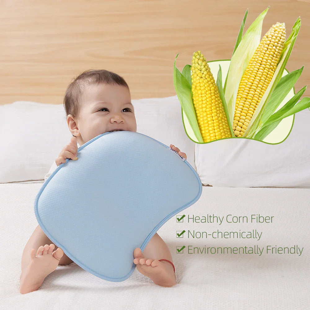 Baby holding a light blue pillow on a bed, with corn and eco-friendly fiber benefits shown