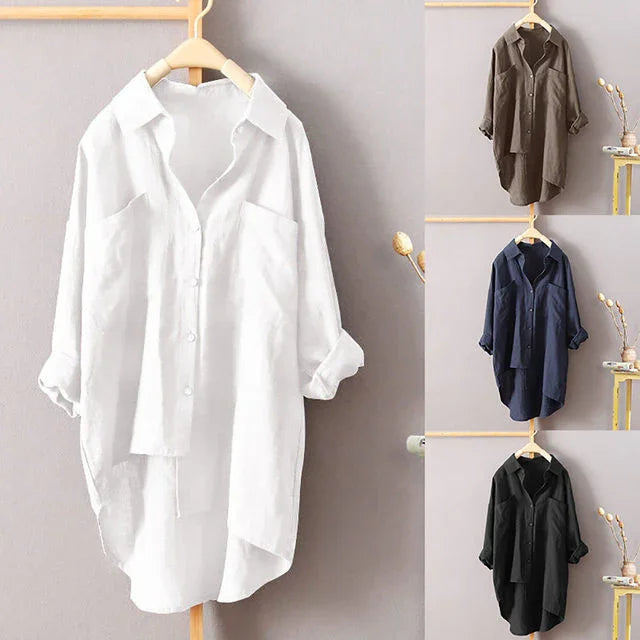Casual oversized button-up shirts in white, brown, navy, and black hanging on wooden hangers against a neutral wall