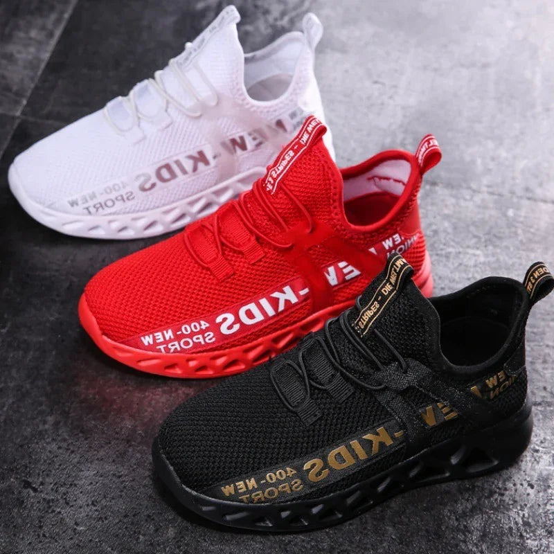 Three sporty kids sneakers in white, red, and black with breathable mesh and bold branded text on a dark floor
