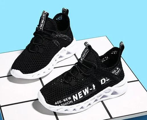 Black mesh sports sneakers with white lattice soles and printed text on sides, displayed on tiled surface